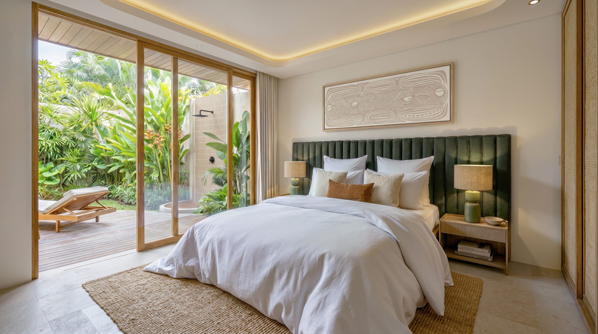 Principal bedroom with green velvet headboard and sliding doors to garden